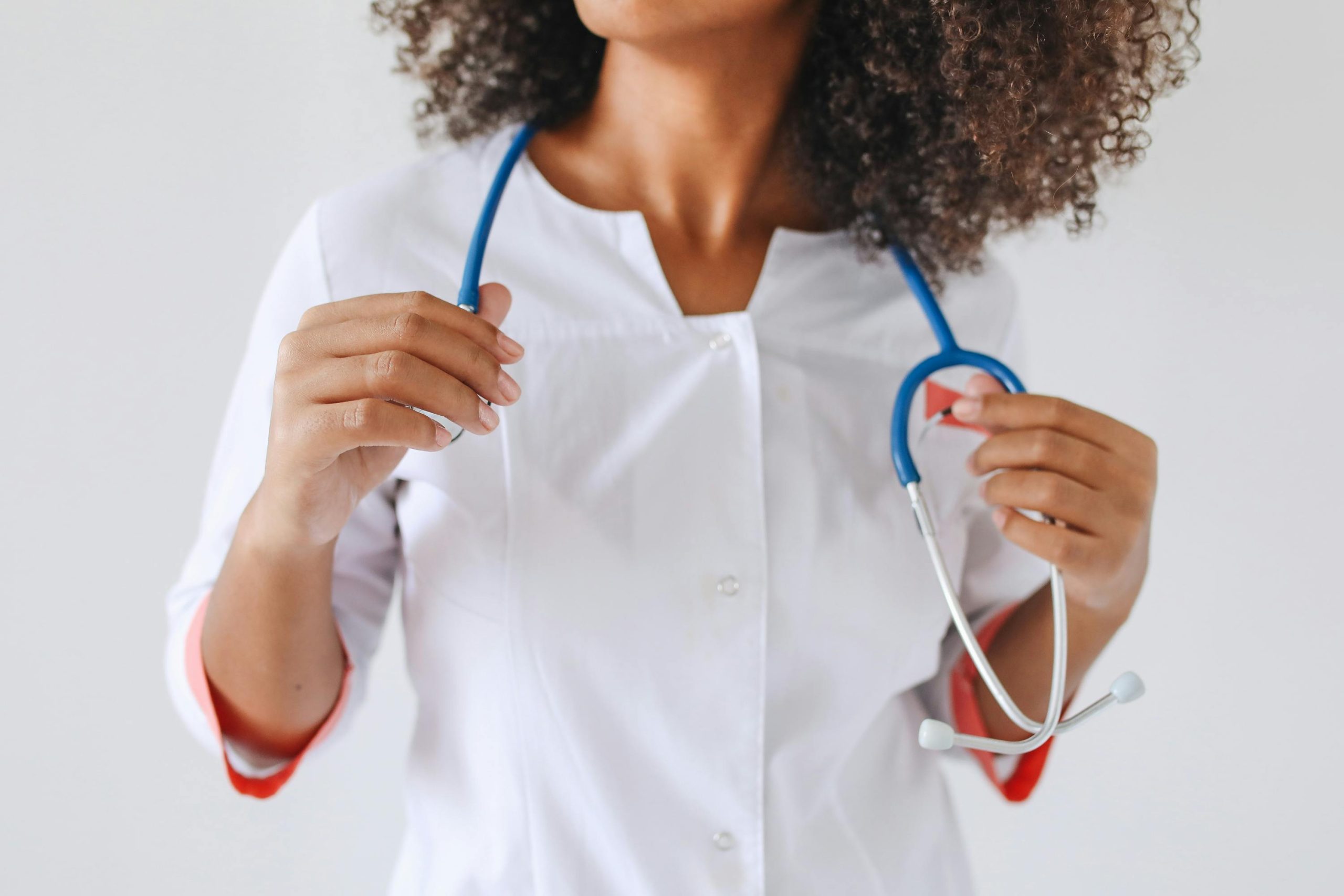 A female doctor holds a stethoscope, focusing on healthcare professionalism.